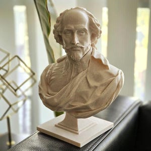 May include: A white bust sculpture of William Shakespeare, the famous playwright, poet, and actor. The bust is on a white square base.