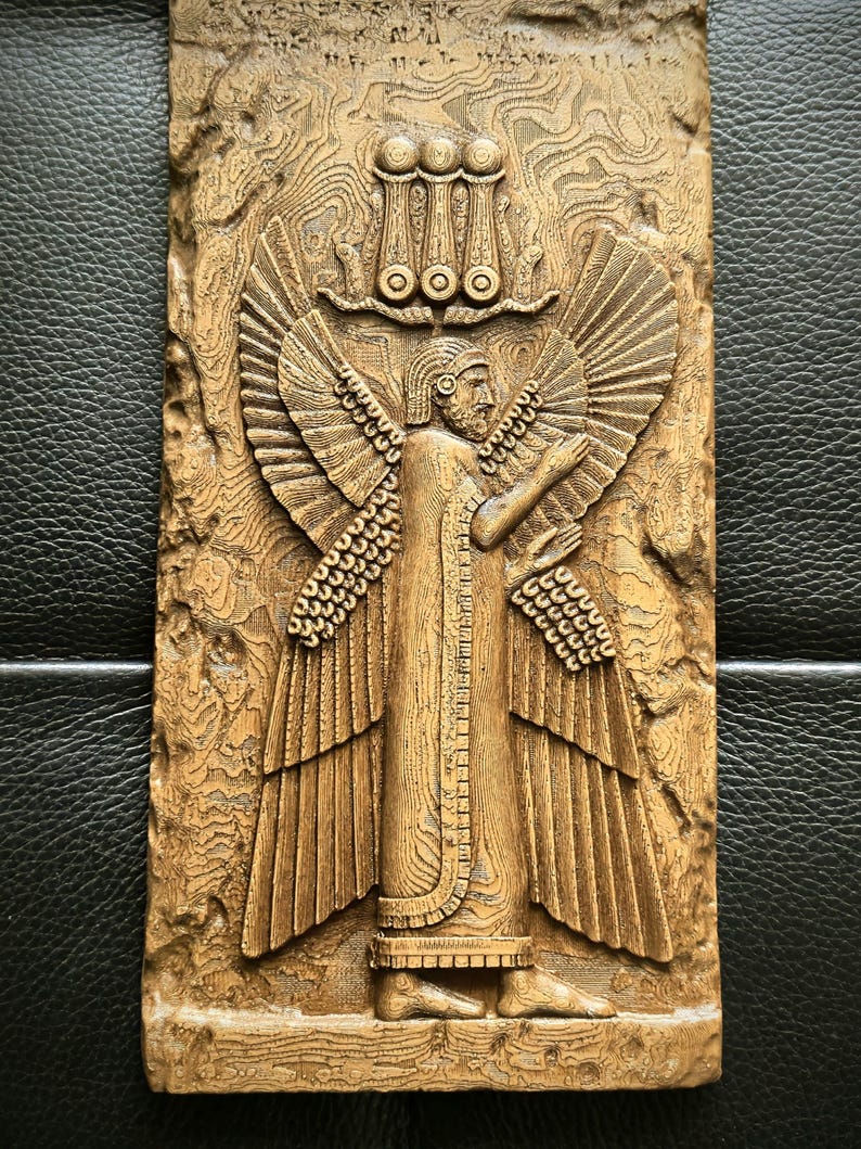 May include: A detailed wooden relief carving of a winged figure with outstretched arms, wearing a long robe and a headdress. The figure has large, detailed wings and stands against a textured background. The relief is in shades of brown.