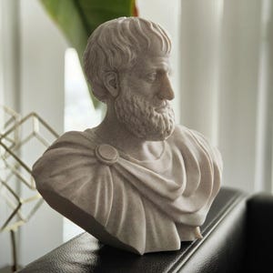 Puede incluir: Un busto de yeso blanco de un hombre con barba y pelo corto. El busto lleva una prenda drapeada.