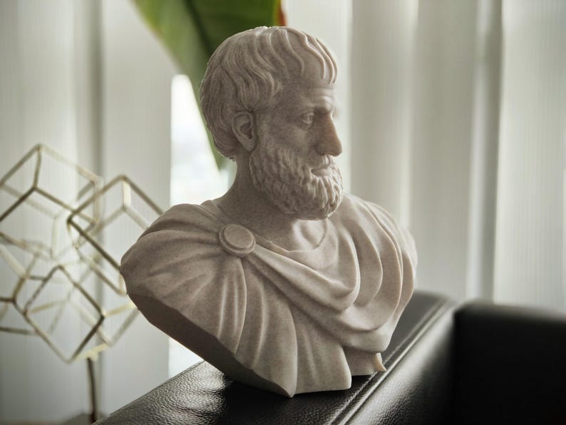 Puede incluir: Un busto de yeso blanco de un hombre con barba y pelo corto. El busto lleva una prenda drapeada.