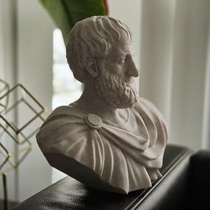 Puede incluir: Un busto de yeso blanco de un hombre con barba y pelo corto. El busto es de estilo cl&aacute;sico y lleva una toga.
