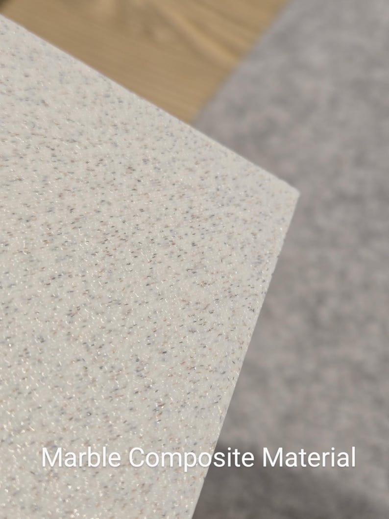 May include: Close-up of a white marble composite material with a speckled texture. The material is smooth and has a subtle shimmer.
