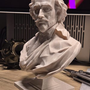 May include: A white 3D printed bust of William Shakespeare. The bust is on a square base and shows Shakespeare's face and upper torso.