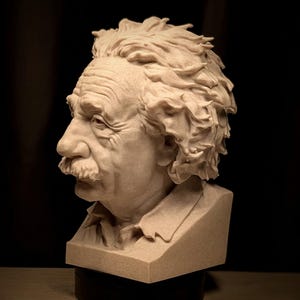 May include: A detailed bust sculpture of Albert Einstein, featuring his iconic hairstyle and mustache. The sculpture is in a light beige color, with visible details of his facial features and clothing. The bust is set against a dark background.