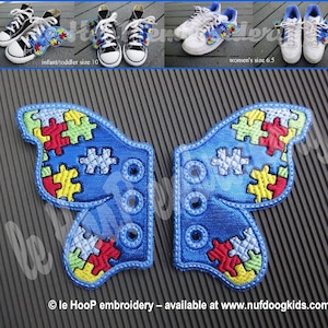 Puede incluir: Dos pares de cordones de zapatos azules en forma de mariposa con un diseño de piezas de rompecabezas en rojo, amarillo, verde y azul. Los cordones son para zapatos de talla 10 para bebés/niños pequeños y talla 6,5 para mujeres. le Hoop embroidery - disponible en www.nufdoogkids.com
