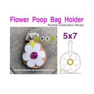 Könnte beinhalten: Maschinenstickdesign für einen blütenförmigen Kotbeutelhalter. Das Design ist 5x7 Zoll groß und zeigt eine weiße Blume mit einer violetten Mitte und grünen Blättern. Das Design ist auf einem Korkuntergrund dargestellt.