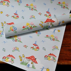 May include: Blue and white wrapping paper with a repeating pattern of red and white mushrooms with houses, blue fairies, and yellow flowers.