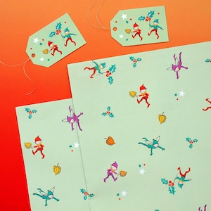 May include: Pale green wrapping paper and gift tags featuring a repeating pattern of elves, holly, stars, and orange berries. The elves are in red, purple, and teal outfits. The tags have string attached, ideal for Christmas gifts.