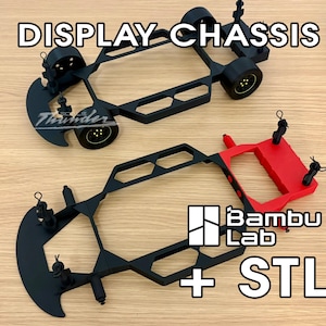 May include: Two 3D-printed display chassis, one black and one red, with wheels attached. The text "DISPLAY CHASSIS" is at the top. The Bambu Lab logo and "+ STL" are also visible.