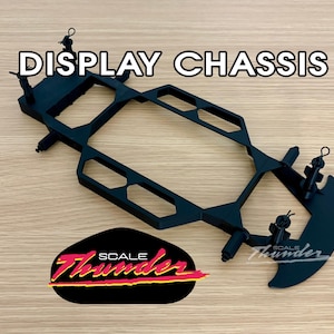 May include: Black display chassis with the text "DISPLAY CHASSIS" in white. The chassis has a unique geometric design and the Scale Thunder logo in red, yellow, and black.