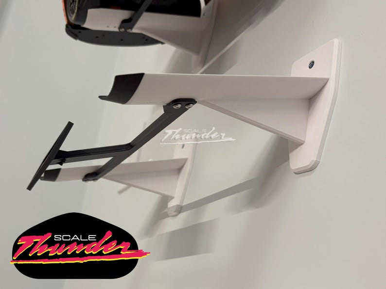 May include: White wall-mounted shelf with a black support bracket, designed to hold a model car. The shelf has a black accent on the front edge. The logo "SCALE Thunder" is visible.
