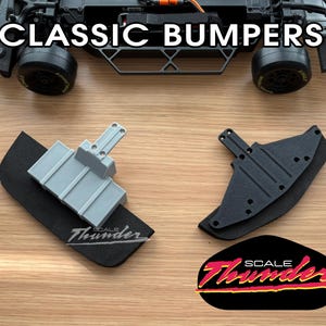 May include: Classic bumpers for a model car. The image shows two bumpers, one gray and one black, with the text "CLASSIC BUMPERS" at the top. The logo "SCALE Thunder" is at the bottom.