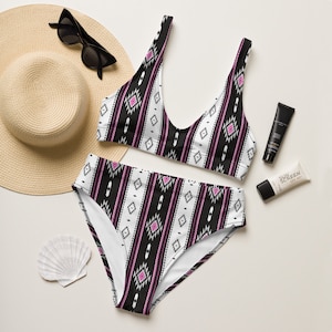 May include: A black and white patterned bikini with pink accents. The bikini top has a scoop neck and the bottoms are high-waisted.