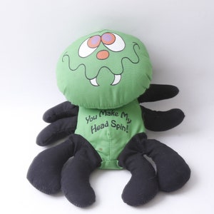 May include: Green plush spider toy with black legs and a face that says "You Make My Head Spin!"
