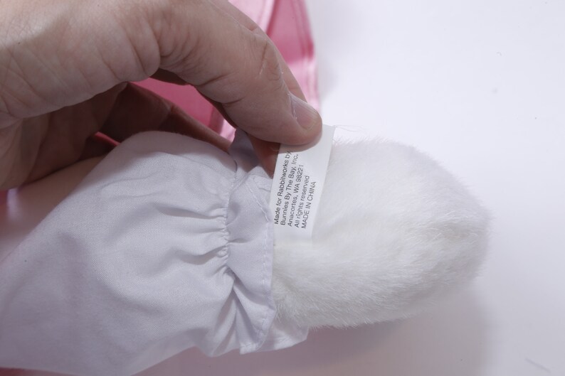Peut inclure: Pompon en fourrure blanche avec une &eacute;tiquette blanche attach&eacute;e. L'&eacute;tiquette indique "Made for Rainbowworks Inc.  Bunnies By The Bay, Inc.  Anacortes, WA 98221  All rights reserved.  MADE IN CHINA."