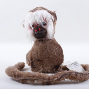 May include: A white ceramic mug with a black handle and the text "But First, Coffee" in a black, handwritten-style font. The mug is on a white surface.