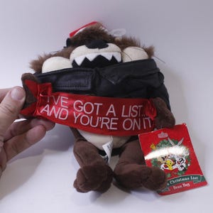 May include: A plush toy of Taz the Tasmanian Devil from the Looney Tunes cartoon. Taz is wearing a black leather jacket and a red ribbon that says "I've got a list... and you're on it".
