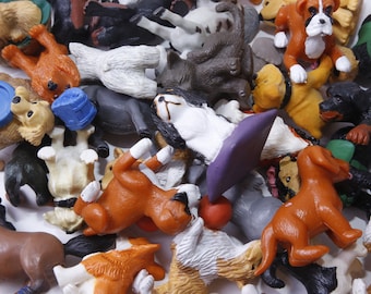 Puede incluir: Una colección de perros de juguete de colores en varias poses. Los perros están hechos de plástico y tienen características realistas. Algunos de los perros llevan accesorios, como sombreros y bufandas.