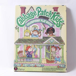 May include: A vintage Cabbage Patch Kids Colorforms Play House box. The box features a two-story house illustration with Cabbage Patch Kids dolls in the windows and on the porch. The box has a green and pink color scheme.