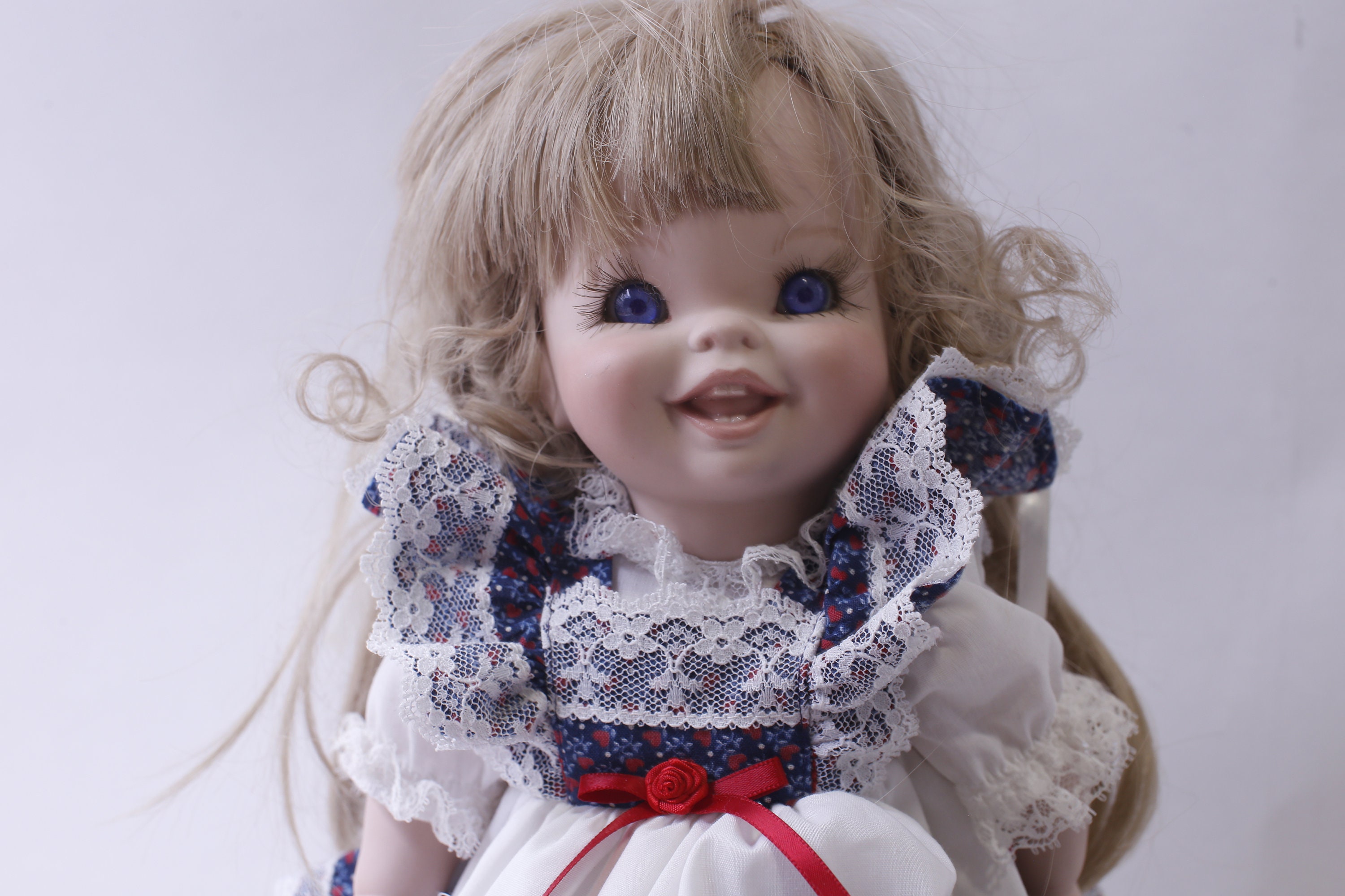 Vintage Porcelain Doll in White Blue Floral Dress, Smiling