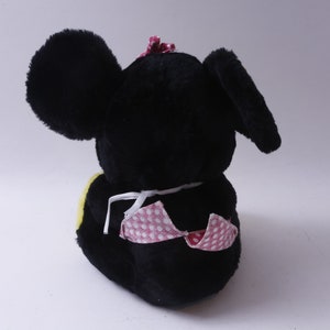 May include: Black plush toy mouse with pink polka dot fabric and a pink bow on its head. The mouse is sitting with its back to the camera.