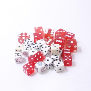 May include: A pile of red and white dice, some with black spots and some with white spots.