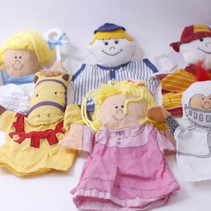 Puede incluir: Conjunto de seis marionetas de mano coloridas, que incluyen una niña con cabello rubio, un niño con uniforme de béisbol, un caballo, una niña con cabello rubio con un vestido rosa, un bombero y un caballero.