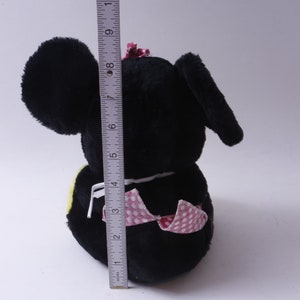 May include: Black plush toy with large ears, a pink bow, and a pink and white polka dot dress. The toy is approximately 6 inches tall.