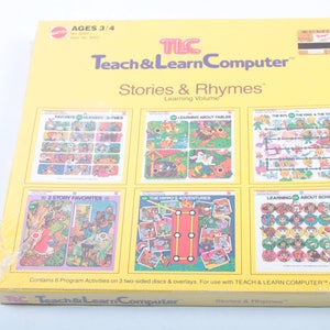 Puede incluir: Una caja amarilla con una imagen de una computadora y el texto "Teach & Learn Computer" y "Stories & Rhymes". La caja contiene seis actividades de programa diferentes en tres discos de doble cara y superposiciones. La caja es para niños de 3 a 4 años.