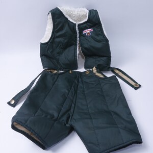 May include: A green quilted vest and matching shorts with a white fleece lining. The vest has a zipper closure and a small patch with the text "Little Bear" on the front.
