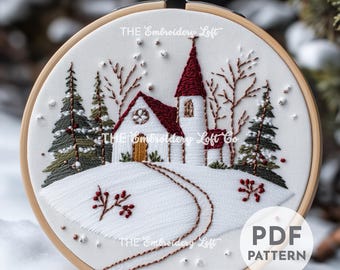 May include: Embroidered design of a white church with a red roof in a snowy winter scene. The church is surrounded by trees and a winding path. The design is in a round embroidery hoop. The text "THE Embroidery Loft Co" is visible in the image.