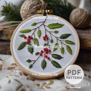 May include: Embroidery pattern for a hoop art design featuring a branch with green leaves and red berries. The pattern is titled "THE Embroidery Loft Co."
