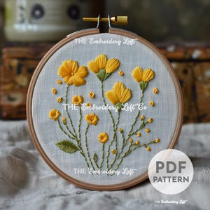 May include: A PDF pattern for embroidery featuring a design of yellow flowers with green stems and leaves on a white linen background. The pattern is in a hoop and the text "THE Embroidery Loft" is visible on the hoop.