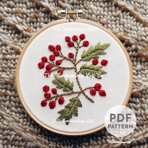 May include: Embroidery pattern for a branch with red berries and green leaves. The pattern is in a hoop and says "PDF PATTERN" on the bottom right corner.