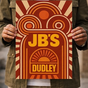 May include: A retro-style poster with a warm color palette of orange, red, and cream. The design features the text "JB'S" in large, bold letters above "DUDLEY" in a stylized font. The artwork includes sunburst and geometric shapes.