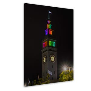 Audace opera d'arte murale LGBTQ+ raffigurante un orologio arcobaleno raffigurante un traghetto, che celebra il mese dell'orgoglio e il viaggio verso l'amore, l'uguaglianza e l'espressione creativa.