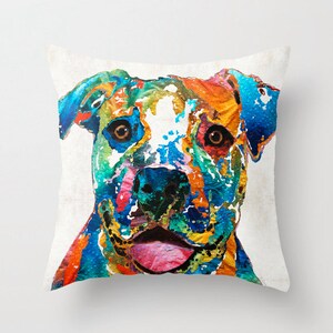 May include: Colorful abstract painting of a pit bull dog's face. The dog's eyes are brown, and the painting is done in a variety of bright colors, including blue, green, yellow, orange, and pink.