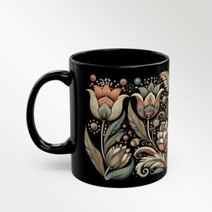 Boho black ceramic coffee mug with tulip floral design, perfect for tea or coffee lovers. Artisan drinkware for vintage-inspired kitchens or bohemian decor. Makes a unique gift for her or a decorative piece for retro and artistic home settings.