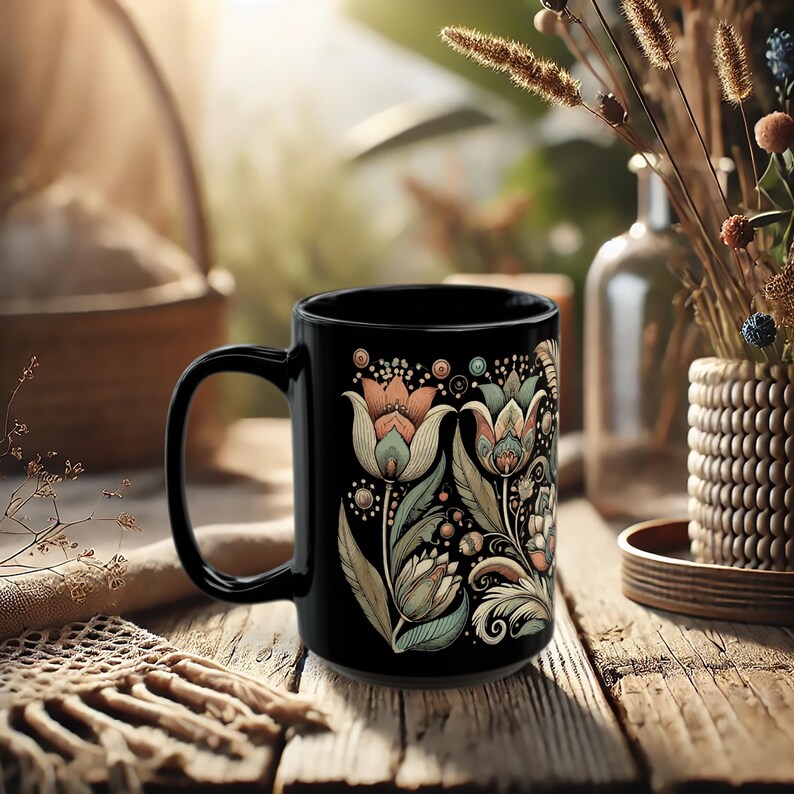 Black ceramic mug featuring a tulip floral design, ideal for tea or coffee enthusiasts. Boho-style artisan coffee cup for bohemian kitchen decor or vintage-inspired gift ideas. A charming addition to your daily routine or a thoughtful present for her