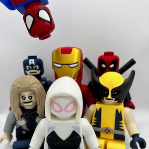 Puede incluir: Un grupo de seis minifiguras de superhéroes, incluyendo Spider-Man, Capitán América, Iron Man, Deadpool, Wolverine y Ghost Spider. Las figuras están hechas de plástico y tienen una variedad de colores, incluyendo rojo, azul, amarillo, negro y blanco.