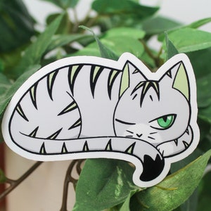 Sticker of a cat with an orange base and green and black stripes representing the aromantic flag.
