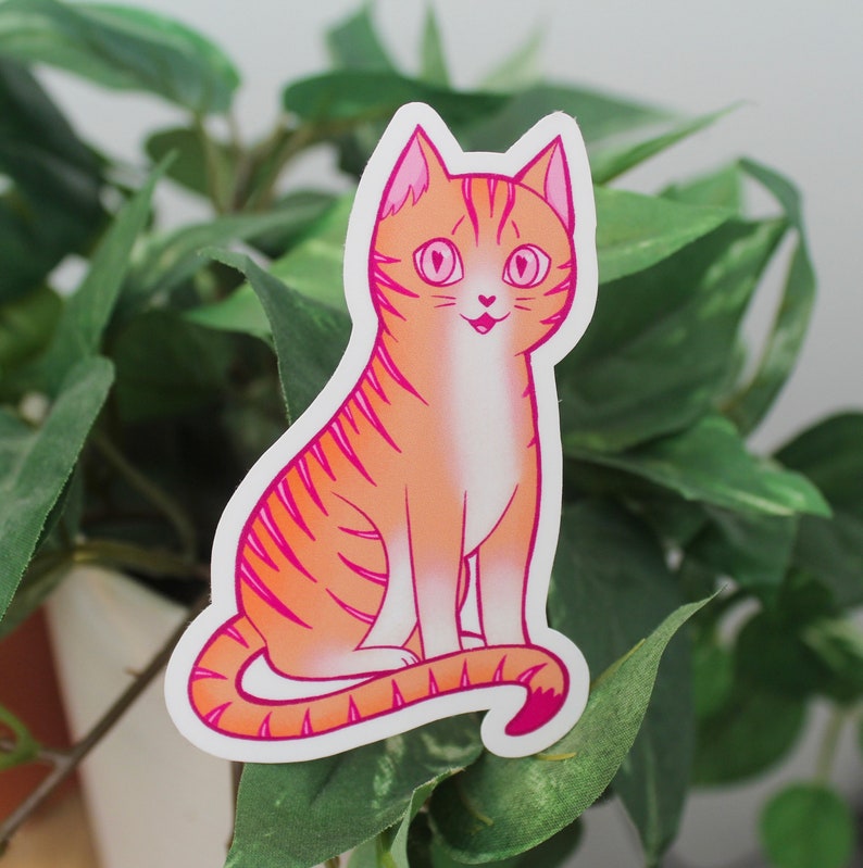 Sticker of an orange cat with pink stripes representing the lesbian flag.
