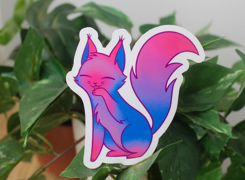 Sticker of a cat with a blue, purple, and pink gradient representing the bisexual flag.