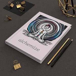 May include: A white journal with a colorful illustration of a person in a meditative pose with a swirling background. The text "alchemize" is printed on the front cover.