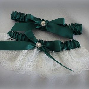 May include: Two white lace garters with emerald green satin bows and rhinestone embellishments.