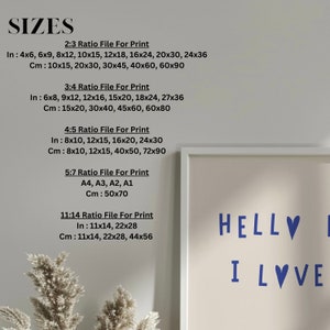May include: A white frame with a light beige background and the text "HELLVI LOVE" in blue. The frame is surrounded by a white mat. The image also includes a list of sizes for printing in inches and centimeters.