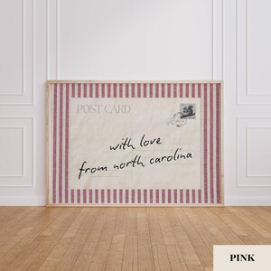 May include: A rectangular framed print featuring a vintage postcard design with a cream-colored background and a red and white vertical striped border. The text reads POST CARD with love from north carolina and includes a small squirrel stamp.