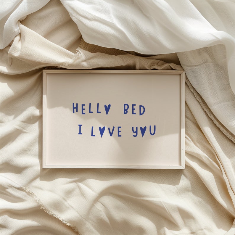 May include: A white framed sign with the text "Hello Bed I Love You" in blue lettering with heart symbols.