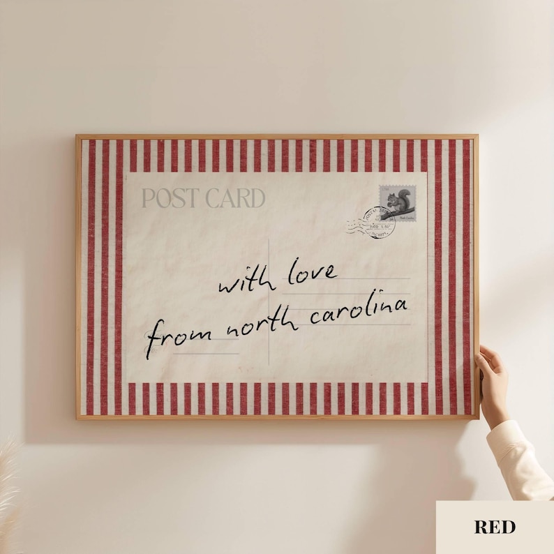 May include: A rectangular framed wall art piece featuring a vintage postcard design with a red and white vertical striped border. The center displays the text POST CARD, a squirrel stamp, and the handwritten script with love from north carolina.