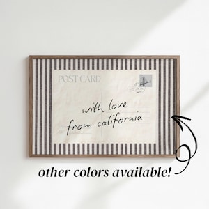 May include: A rectangular framed print featuring a vintage postcard design with the text "POST CARD" and "with love from california" in black script. The postcard is centered against a background of vertical black and white stripes.